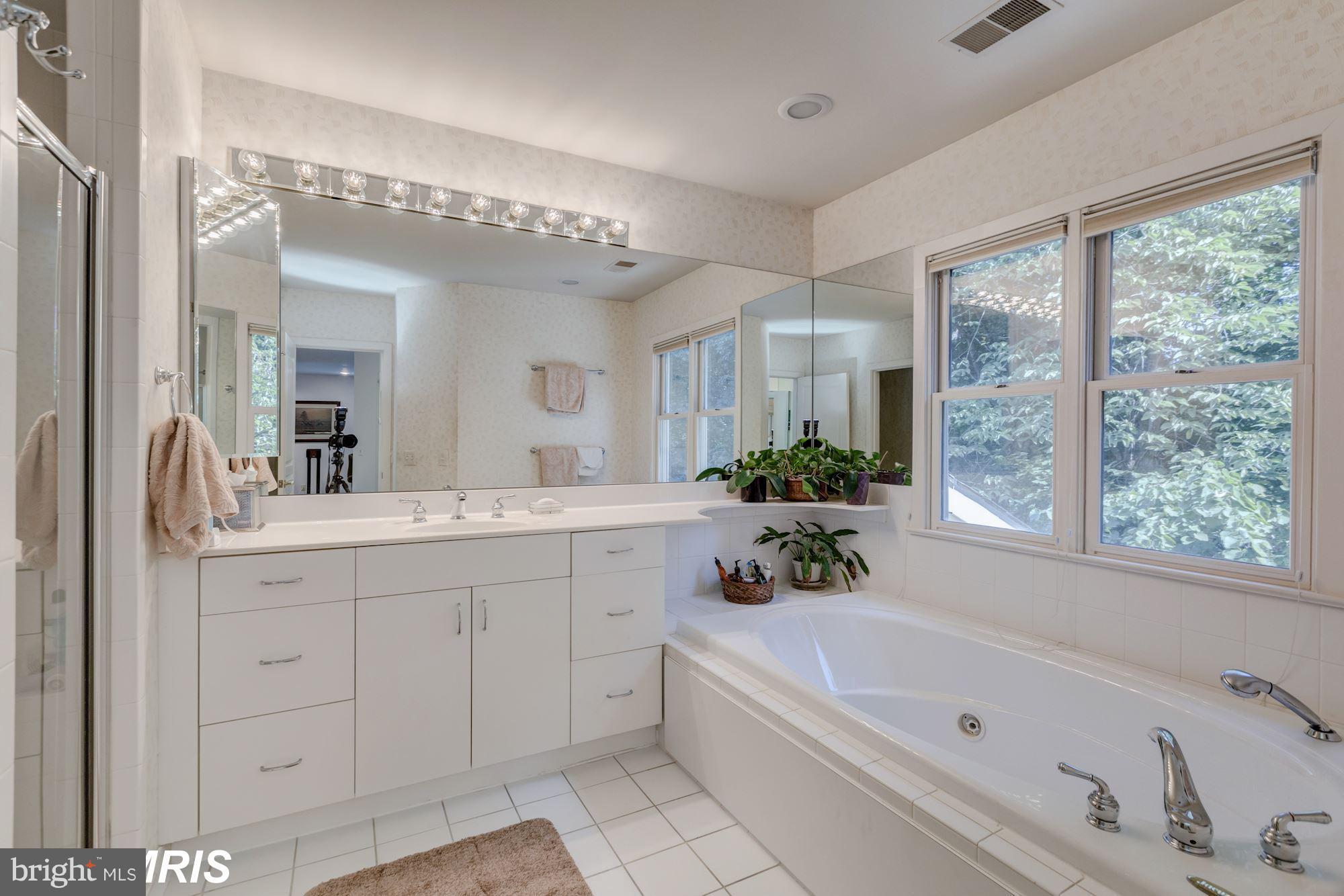 6900 Rannoch Road Bethesda, MD 20817 - Photo 9 of 22 a bathroom with a granite countertop tub a sink and a large mirror
