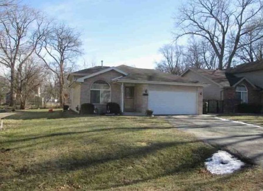 16107 Spaulding Avenue Markham, IL 60428 - Photo 2 of 2 a front view of a house with a garden