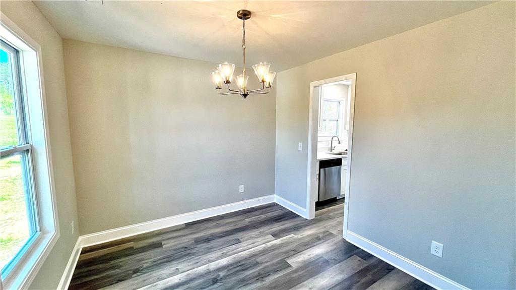 5 Green Road Griffin, GA 30224 - Photo 6 of 34 a view of a chandelier in an empty room with wooden floor and a window