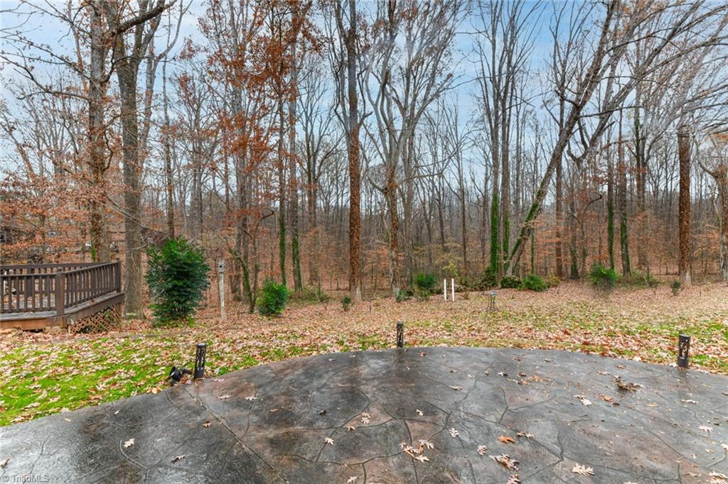 2010 Trosper Road Greensboro, NC 27455 - Photo 24 of 25 Walk-out patio off the lower level and 2nd deck in the gorgeous wooded backyard