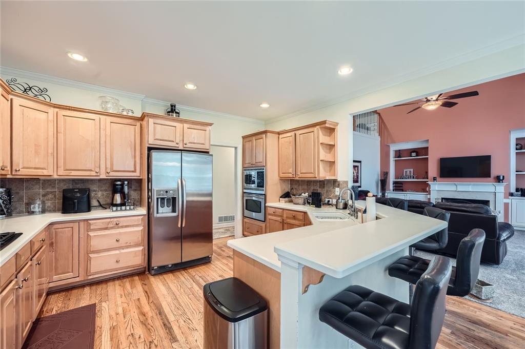 5106 Vining Estates Way Mableton, GA 30126 - Photo 11 of 28 a kitchen with stainless steel appliances a stove a sink a refrigerator and white cabinets with wooden floor