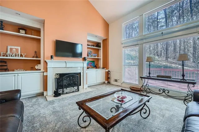 a living room with furniture a flat screen tv and a fireplace
