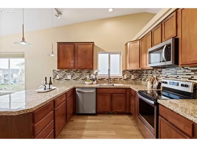 a kitchen with stainless steel appliances granite countertop a sink stove and microwave