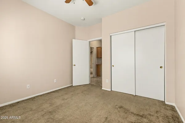 an empty room with fan and windows