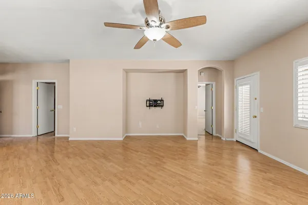 a view of an empty room with a window and wooden floor