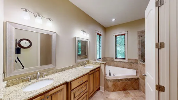 a bathroom with a granite countertop double vanity sink and a mirror