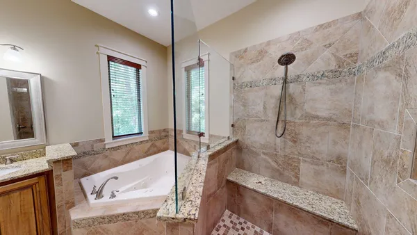 a bathroom with a tub a sink and a large mirror