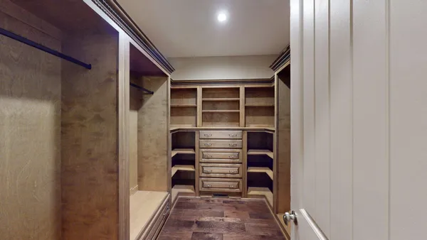 a view of walk in closet with empty racks