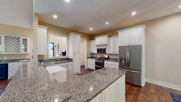 a kitchen with stainless steel appliances granite countertop a sink refrigerator and microwave