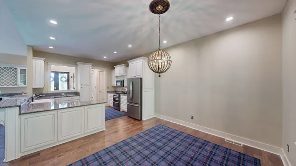 a large kitchen with a lot of cabinets and wooden floor
