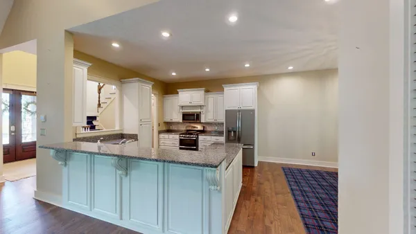 a kitchen with kitchen island a sink stove and refrigerator