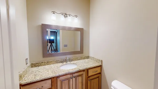 a bathroom with a granite countertop sink and a mirror