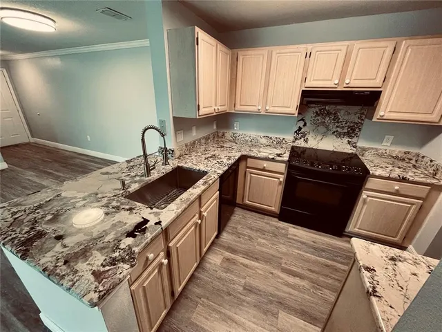 a kitchen with stainless steel appliances granite countertop a sink stove and refrigerator