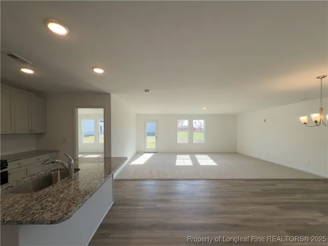 a large white kitchen with sink and natural light