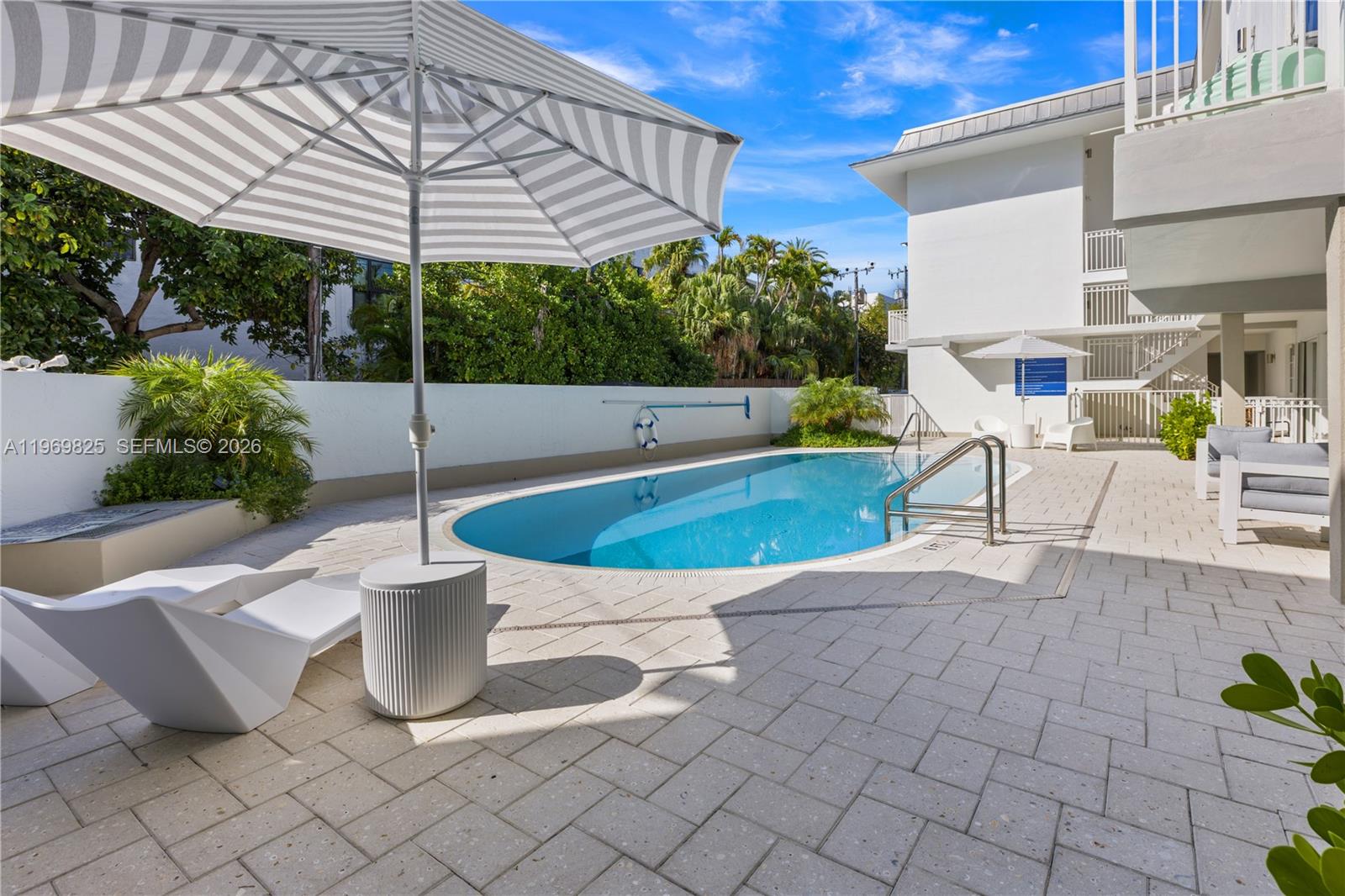 290 Sunrise Drive, Unit 2L Key Biscayne, FL 33149 - Photo 5 of 16 a view of a patio with a table and chairs under an umbrella