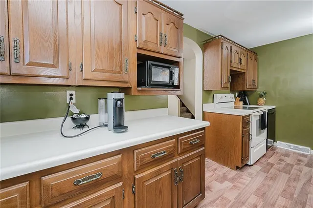 a kitchen with stainless steel appliances granite countertop a sink a stove and cabinets