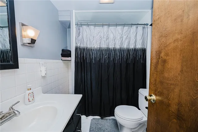a bathroom with a sink a toilet and shower curtain