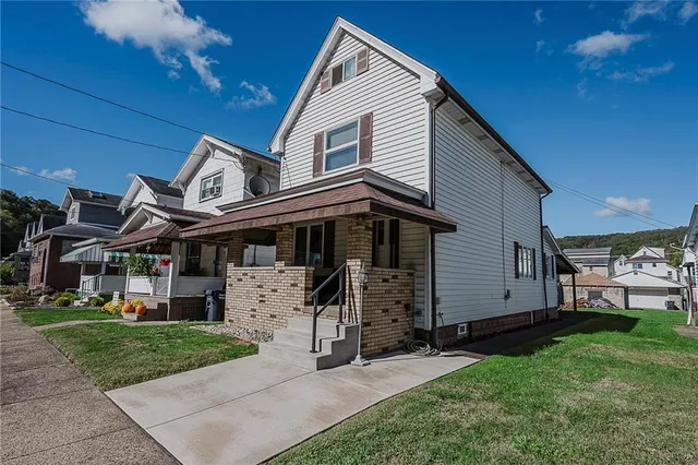 a view of a house with a yard and furniture