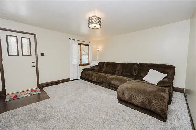 a living room with a couch and a dresser next to a window