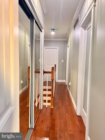 a view of a hallway with wooden floor and furniture