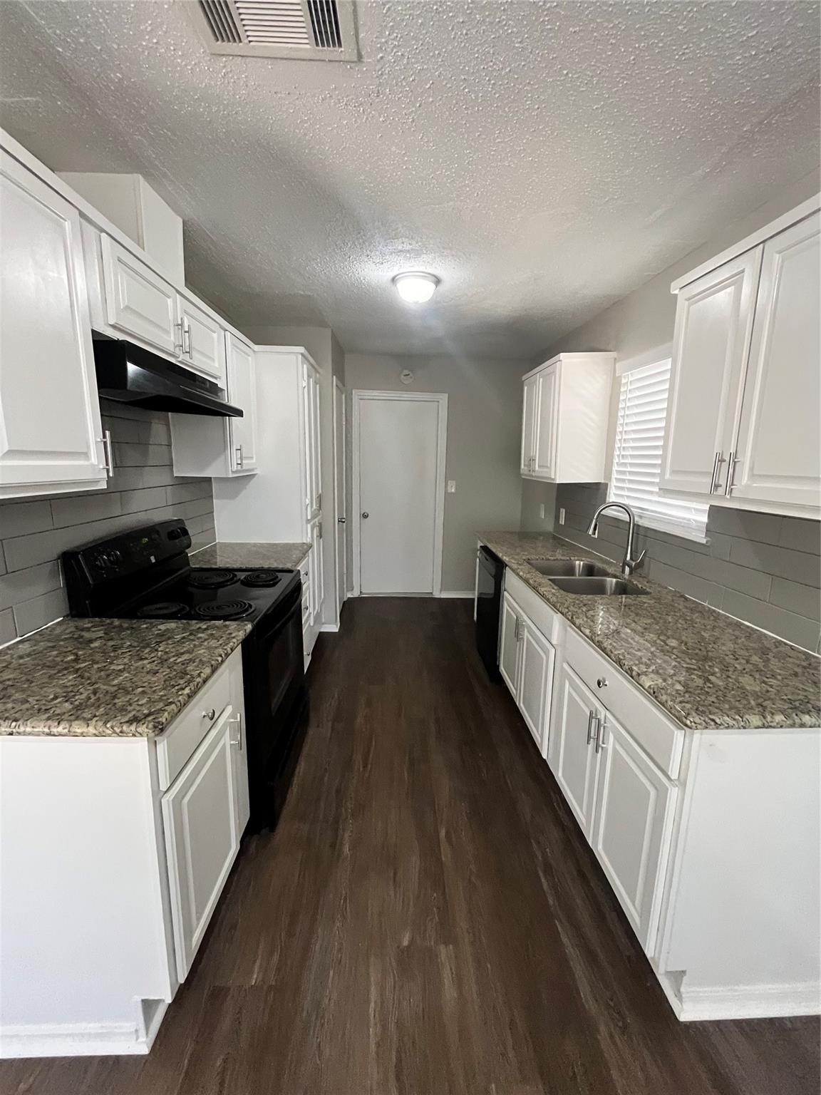 22318 Meadowgate Drive Spring, TX 77373 - Photo 7 of 8 a kitchen with granite countertop wooden floors a stove and a sink