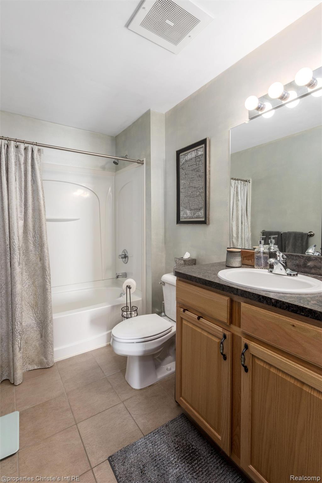 66 Winder Street, Unit 332 Detroit, MI 48201 - Photo 19 of 30 Bathroom featuring vanity, shower / bath combination with curtain, and light tile patterned flooring