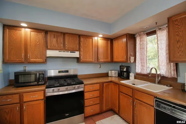 a kitchen with stainless steel appliances granite countertop a sink stove and microwave