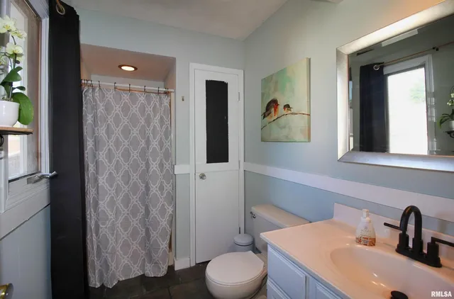 a bathroom with a toilet a sink and mirror
