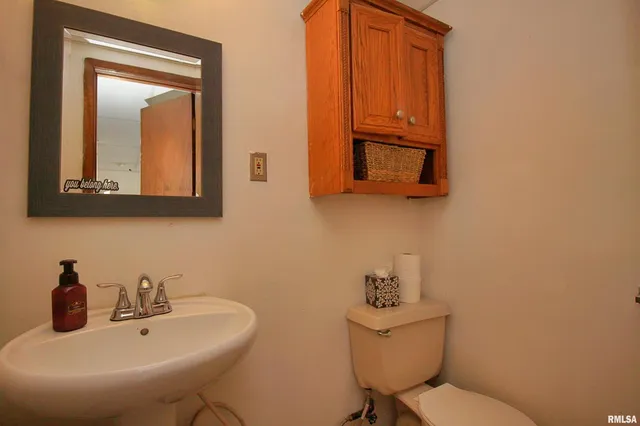 a bathroom with a toilet sink and mirror