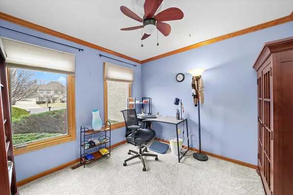 a view of a workspace with furniture and a window