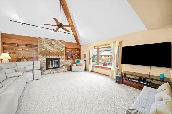 a living room with furniture a flat screen tv and a floor to ceiling window