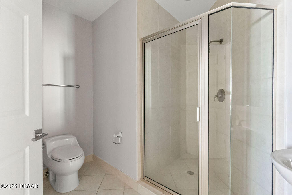 241 Riverside Drive, Unit 2610 Daytona Beach, FL 32117 - Photo 23 of 31 a bathroom with a granite countertop toilet and a shower