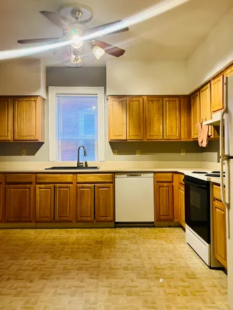 a large kitchen with stainless steel appliances granite countertop a sink a stove cabinets counter space and a window