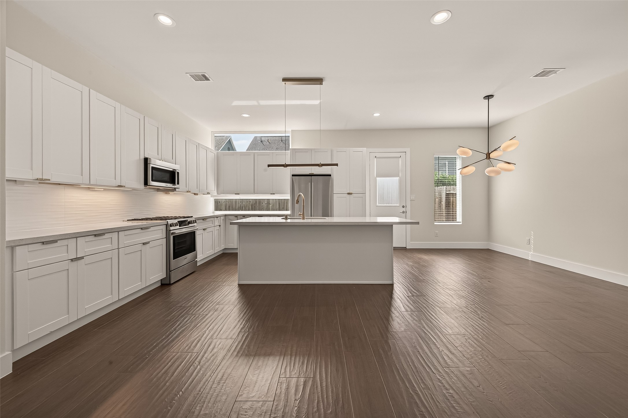 5505 Robusto Place Houston, TX 77091 - Photo 12 of 49 a large kitchen with cabinets wooden floor and stainless steel appliances