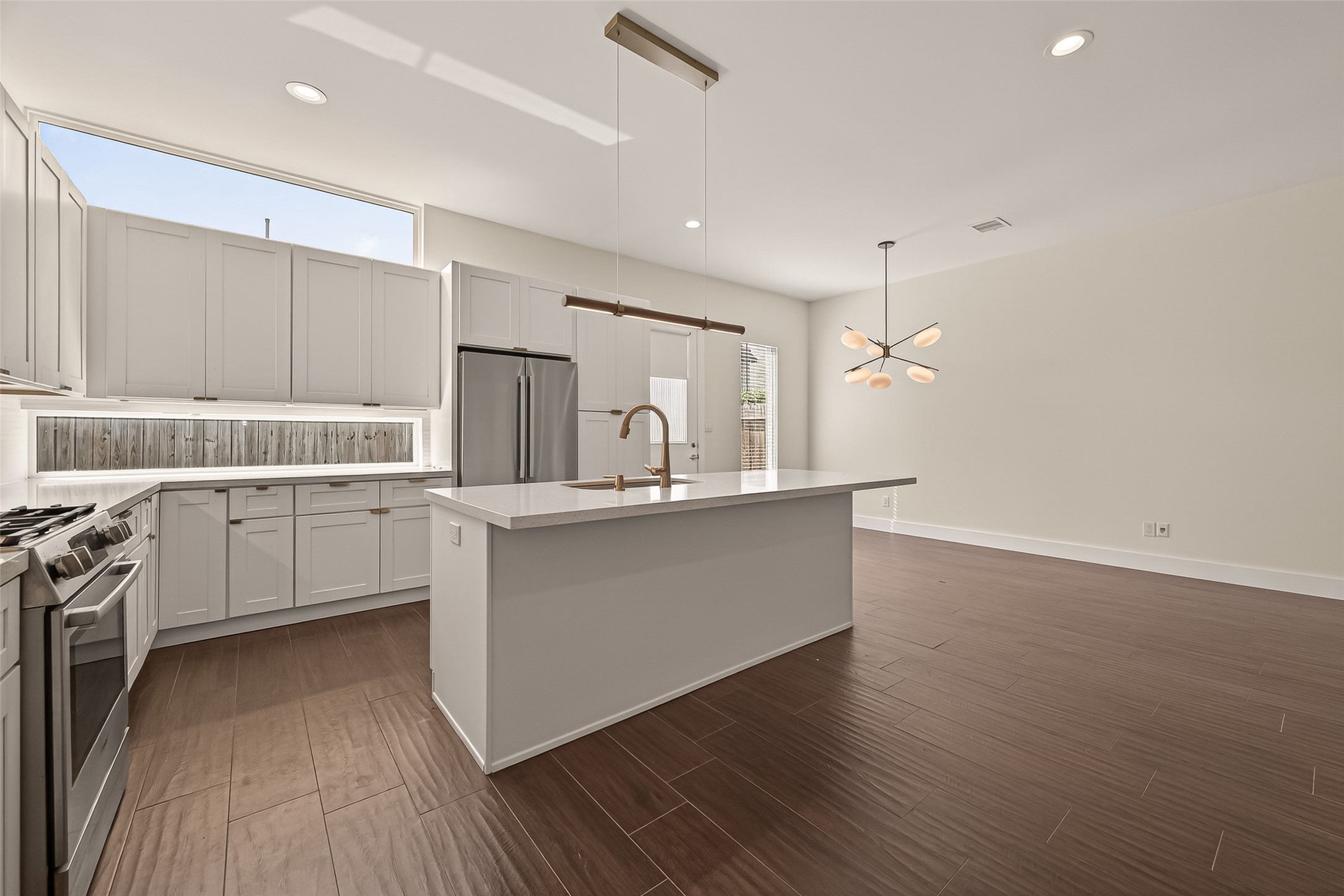 5505 Robusto Place Houston, TX 77091 - Photo 17 of 49 a large kitchen with white cabinets a sink dishwasher a stove and a refrigerator with wooden floor