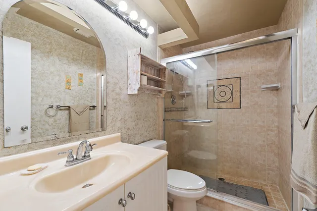 a bathroom with a sink mirror shower and toilet