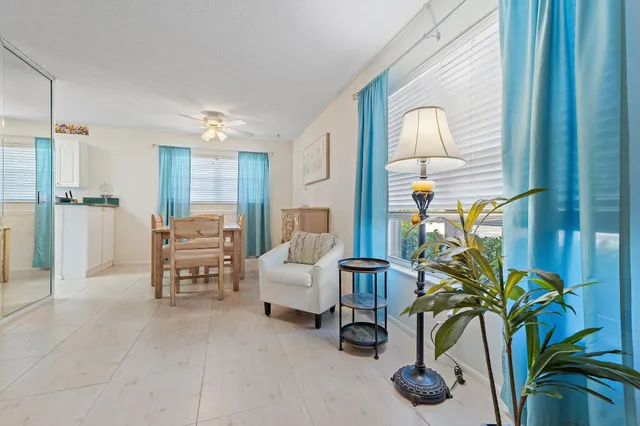 a living room with furniture flowerpot and a chandelier