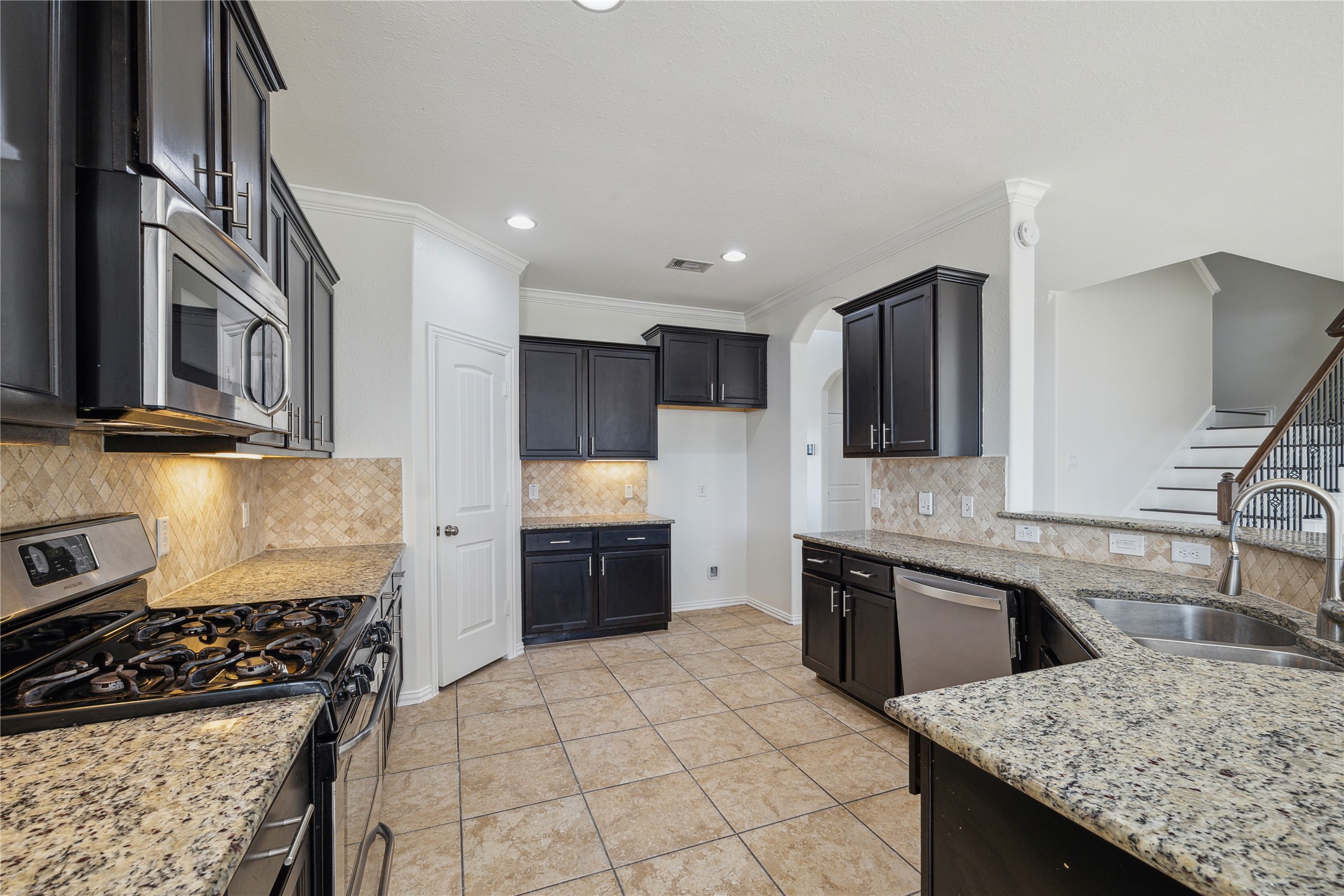 13108 Summit Harvest Lane Rosharon, TX 77583 - Photo 2 of 11 a kitchen with granite countertop stainless steel appliances a sink stove top oven and cabinets