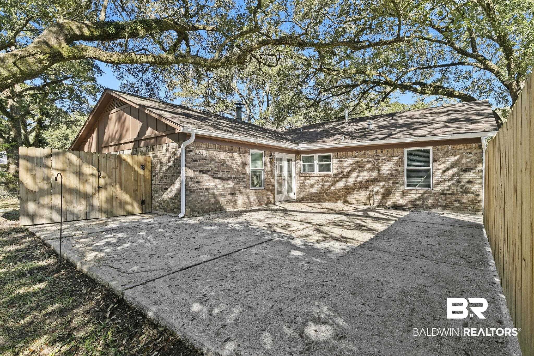 5817 Woodgate Road Mobile, AL 36609 - Photo 69 of 85 Rear view of house featuring a patio, brick siding, and fence
