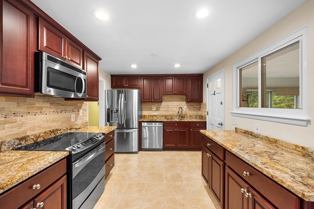 31 Livoli Road Framingham, MA 01701 - Photo 2 of 32 a kitchen with stainless steel appliances granite countertop a stove top oven a sink dishwasher a refrigerator and a oven with wooden cabinets