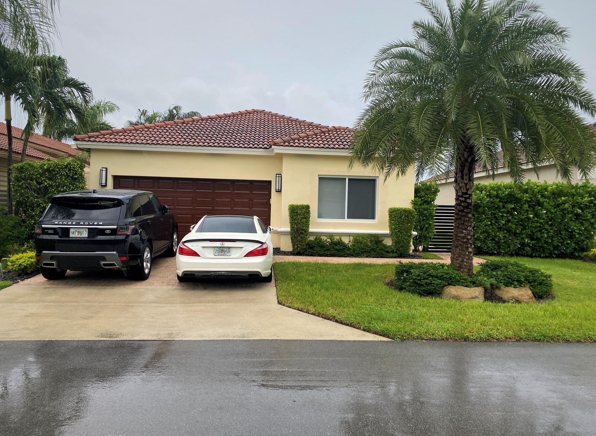 7110 Northwest Turtle Walk Boca Raton, FL 33487 - Photo 1 of 36 a car parked in front of a house