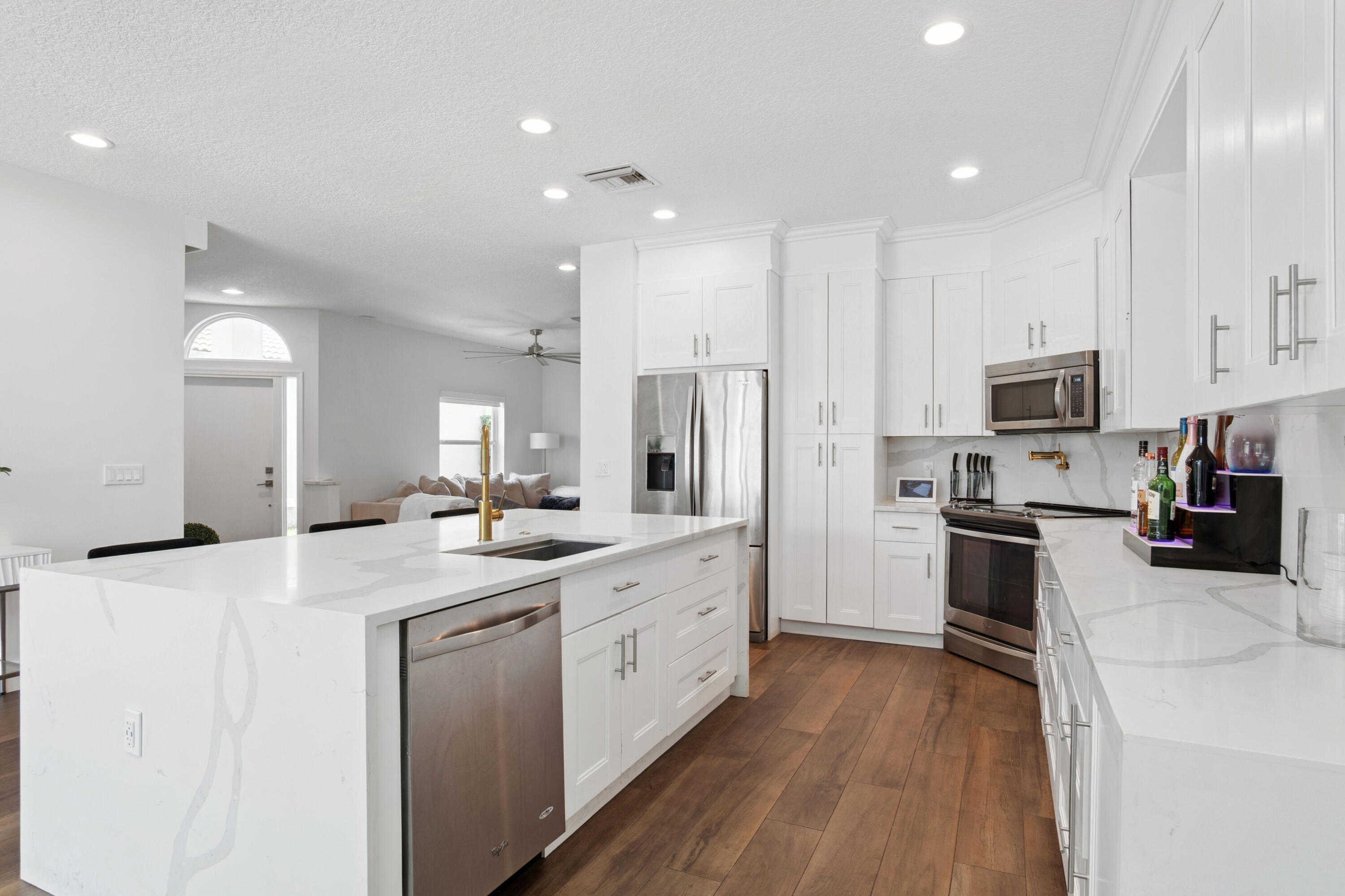 7110 Northwest Turtle Walk Boca Raton, FL 33487 - Photo 24 of 36 a large kitchen with stainless steel appliances lots of counter space and wooden floor