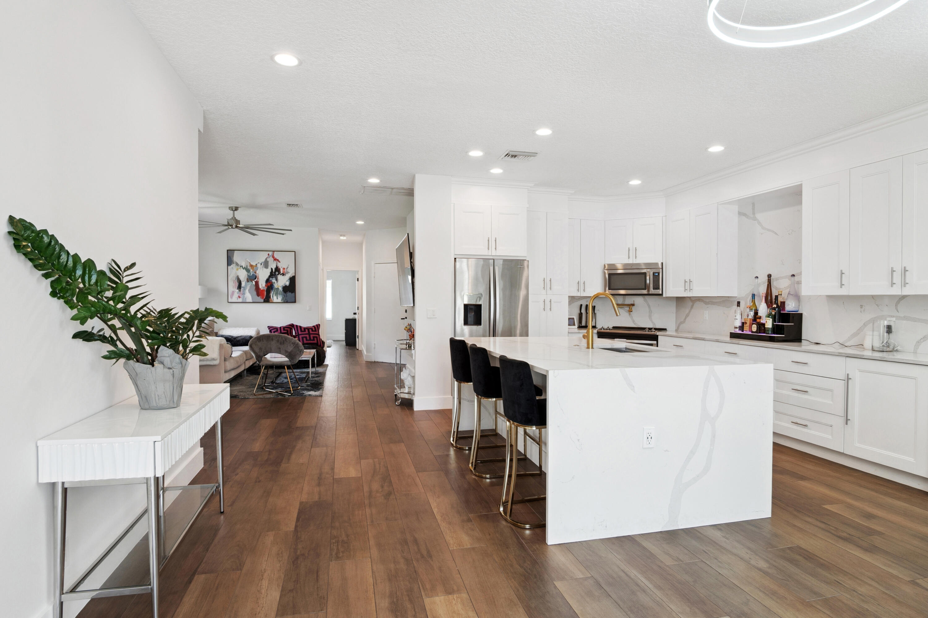 7110 Northwest Turtle Walk Boca Raton, FL 33487 - Photo 28 of 36 a kitchen with stainless steel appliances kitchen island granite countertop a stove top oven a sink a dining table and chairs with wooden floor