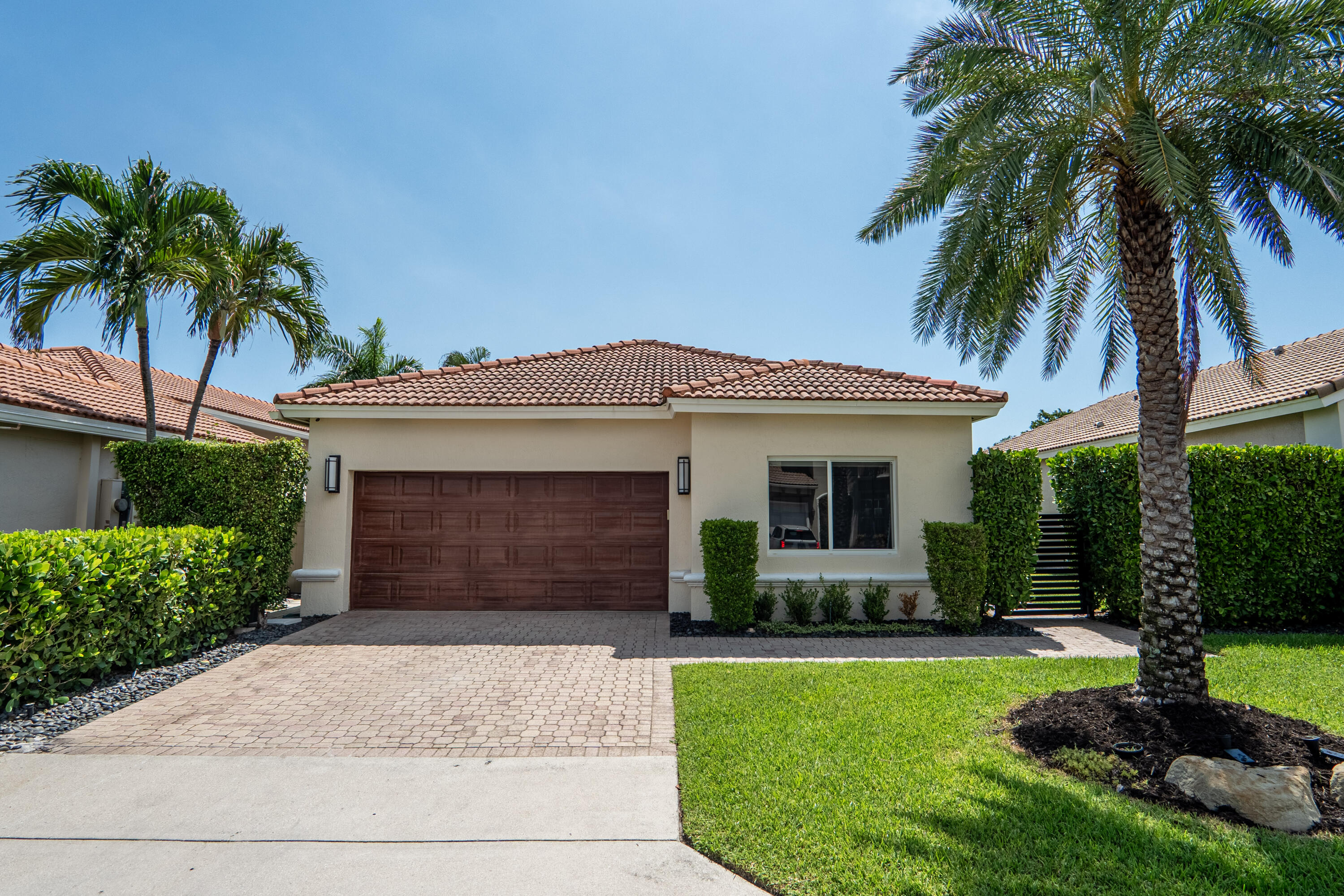 7110 Northwest Turtle Walk Boca Raton, FL 33487 - Photo 30 of 36 a front view of a house with a garden and yard