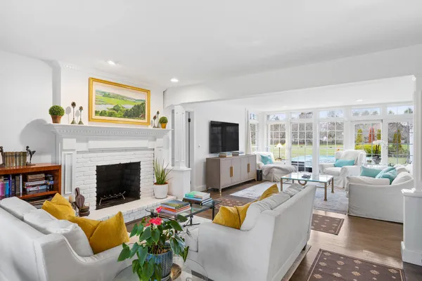 a living room with furniture fireplace and a large window