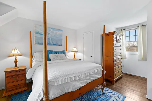 a bedroom with a bed a dresser and a window