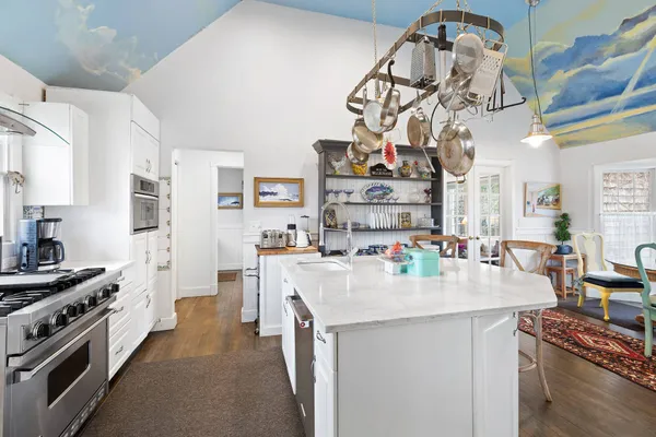 a kitchen with a sink a stove and chairs
