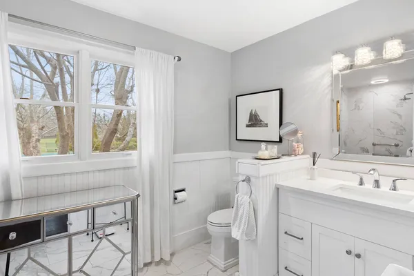 a bathroom with a toilet a sink and a large mirror