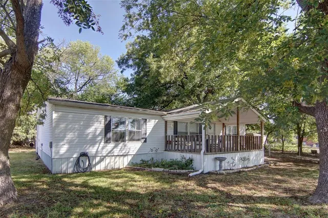 a view of a house with backyard and a tree