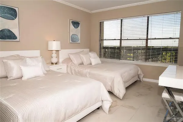 a bedroom with two beds and a large window